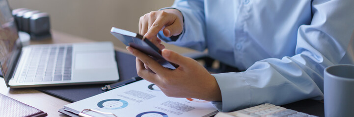 Startup business concept, Businesswomen check and read financial data on smartphone at workplace