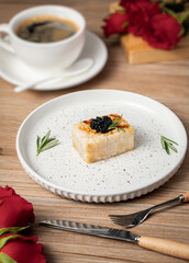 Thick sliced fish fillets and caviar, delicate cuisine in a western restaurant, on a white plate with red roses as a background