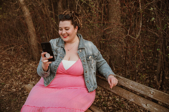 plus size woman smiles at phone
