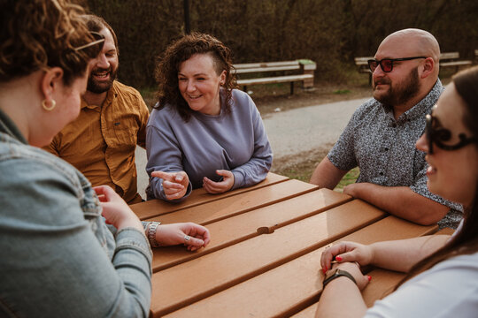 5 friends sit around table talking