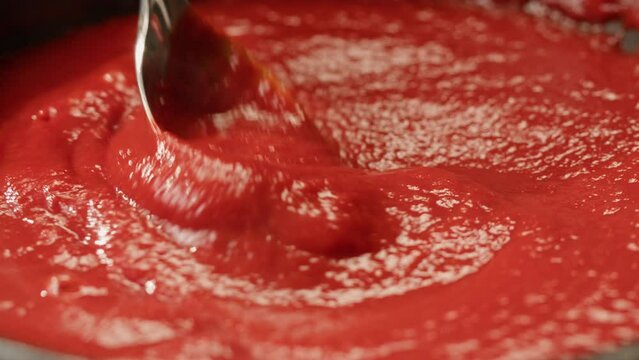 Cooking tomato sauce classic homemade Italian tomato sauce with basil for pasta and pizza in the pan. Chef cooking traditional Italian food.