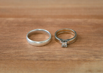 Wedding rings on wood surface isolated. White gold metal.
