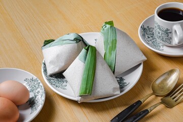 Asian cuisine Nasi Lemak is a rice dish infused with coconut milk. Wrap in banana leaf and brown paper.
