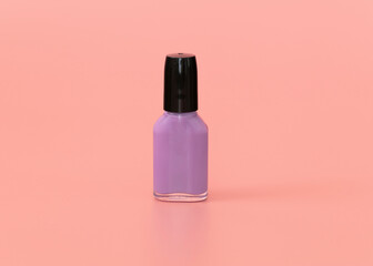 Lilac nail polish bottle on pink background. Copy space.