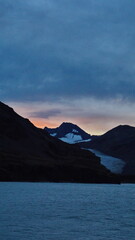 Fototapeta premium Sunset over mountains with a glacier at Fortuna Bay, South Georgia Island