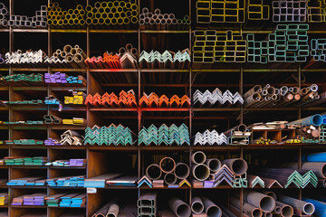 Various shape of many different steel bars and tubes for sale on storage shelf of building supply...