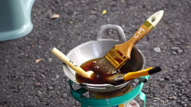 The wax (Indonesian call it malam) melts in the pan. This wax is used in the process of making batik cloth