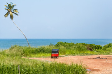 Tuk tuk parked on the shores of the Indian Ocean in Sri Lanka