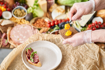 The waiter makes bruschetta or tapas. Table full of mediterranean appetizers, tapas or antipasto. Assorted Italian food set. Delicious snack on party or picnic time. Italian style banquet. 