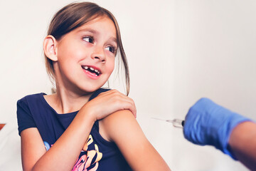 Naklejka premium Girl afraid of injections at the doctor's office. girl is experiencing pain and fear from the vaccination.