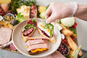 The waiter makes bruschetta or tapas. Table full of mediterranean appetizers, tapas or antipasto. Assorted Italian food set. Delicious snack on party or picnic time. Italian style banquet. 