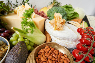 Brie cheese with honey close-up. Table full of mediterranean appetizers, tapas or antipasto. Assorted Italian food set. Delicious snack on party or picnic time. Italian style banquet. 