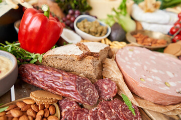 Salami sausage close-up. Table full of mediterranean appetizers, tapas or antipasto. Assorted Italian food set. Delicious snack on party or picnic time. Meat and cheese. Italian style banquet. 