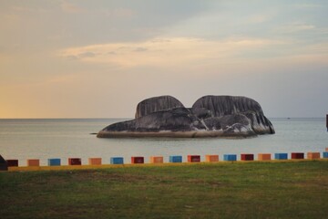 The view on the beach in the morning and there are big rocks