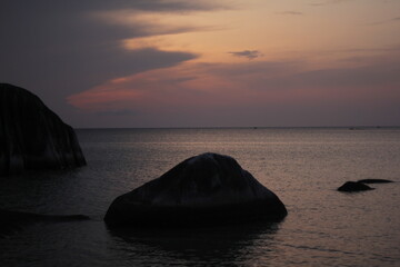 The view on the beach in the morning and there are big rocks