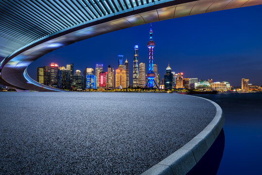 Asphalt road platform and city skyline with modern building at night in Shanghai, China.