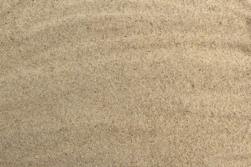 Fototapeta na wymiar Texture of beige loose sand.