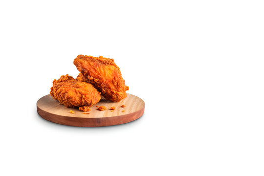 Crispy delicious fried chicken on a round wooden board isolated on white background with copy space. Created with Generative AI Technology