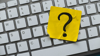 Q&A or questions and answers concept. Yellow sticker with handwritten question symbol over computer keyboard.