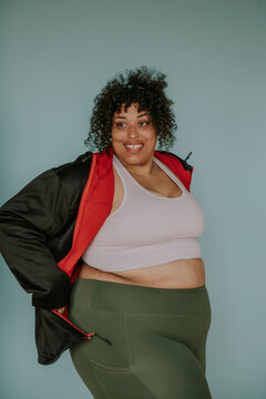 portrait of a plus size afro indigenous person smiling and wearing workout gear