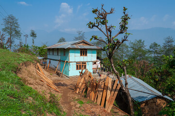 View of Sikkim village with affordable home stays for tourists, blue sky and Himalayan mountains in the background. Sikkim has a very thriving tourism industry based on tourists visiting Sikkim,India.