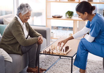 Women, chess and nurse with a senior patient, retirement home and happiness with healthcare. Female person, medical professional and mature lady with employee, nursing and care with games and relax - Powered by Adobe