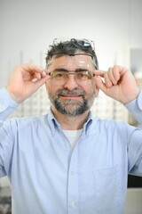 Fototapeta premium Glasses check, senior vision and elderly man at a consulting optometry clinic for wellness. Happy, smile and old face with lens, frame and eyewear choice in a store for help getting a prescription.