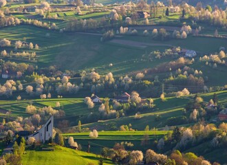 Beautiful countryside around Hrinova city with green fields, blooming cherry trees and white church on the top of th hill. Amazing spring landscape of Podpolanie region, Slovakia.  © Ivan