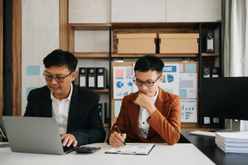 Two business workers talking on the smartphone and using laptop at the home office.