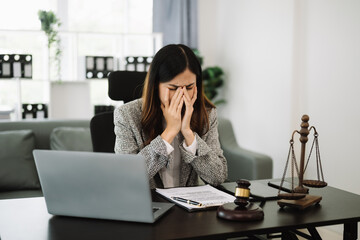 Asian lawyer woman working with a laptop and tablet in a law office. Legal and legal service concept.
