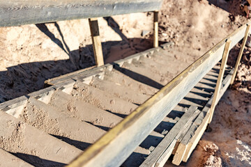 Descent into a deep pit during the construction of the building. Safety in construction. Ladder for descending to reinforced concrete foundations. Ladder to success. Wooden ladder for workers.