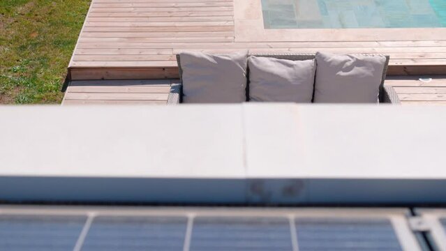 Slow revealing shot of solar panels on a villas rooftop with a private pool in Montpellier