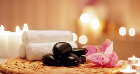 Candles, towels and hot stones at a spa for a massage, healing or luxury treatment therapy. Health,...