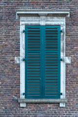 Window with wooden blinds on bricks wall
