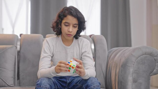 Indian kid boy solving Rubik's cube