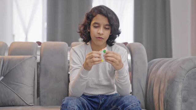 Smart Indian kid boy solving Rubik's cube