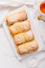 Homemade apple strudel with cinnamon, apple pie with cup of fruit tea