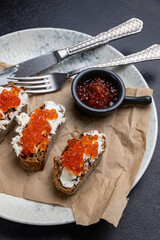 A plate of toasts with red caviar