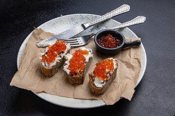 A plate of toasts with red caviar