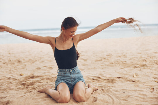 woman sand smile sea vacation carefree nature sitting travel freedom beach