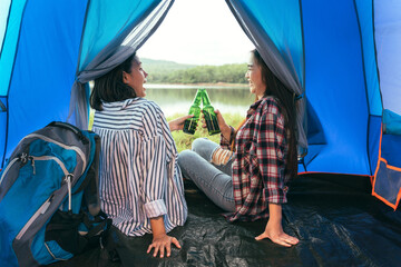 Asian LGBTQ+ couples drinking drinks in a romantic atmosphere inside a camping tent, LGBTQ couples watching nature, rivers, forests, camping atmosphere., LGBTQ lesbians, lesbians.