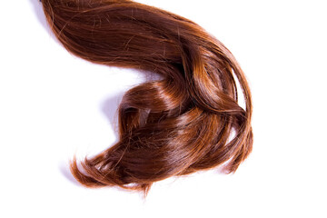 a strand of natural red hair on a white background brown hair