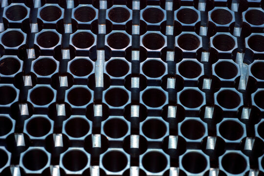 96-well blue metallic Polymerase Chain Reaction (PCR) machine thermal block. Each hole is designed to hold a small reaction tube. 