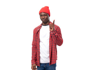 smart young african man in red plaid shirt pointing with index finger at idea over isolated white background