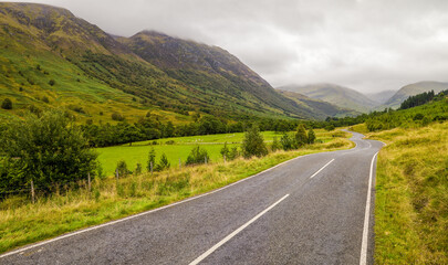 Naklejka premium road in mountains through hills