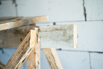 Wooden homemade scaffolding close-up against the background of a bare aerated concrete wall