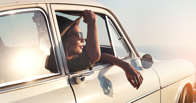 Road trip, window and flare with a woman in a car for travel, freedom or ride as a tourist on a coast in summer. Nature, sunset or vacation with a female traveler taking a drive outdoor for adventure