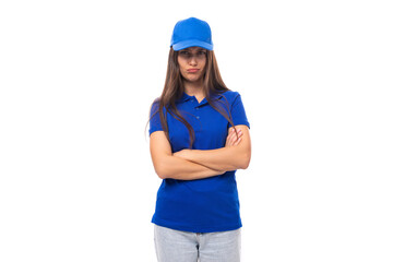 pensive pretty young brunette woman in blue cap and t-shirt with mockup for print on white background with copy space