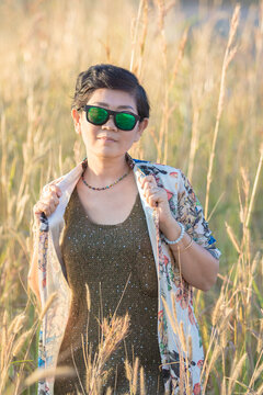beautiful asian woman wearing sunglasses standing in grass field