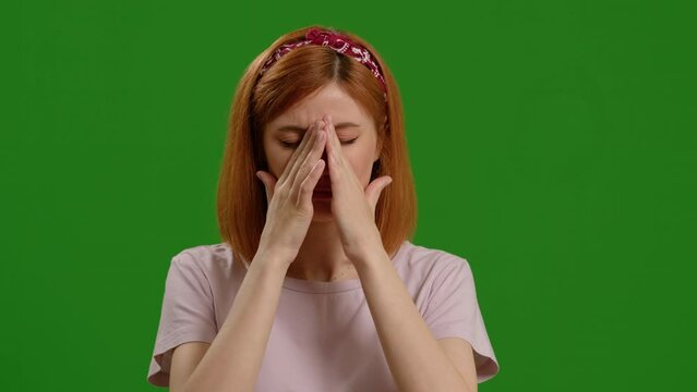 Woman touches her nose tries to sneeze on green screen background. Difficulty breathing, clogged nasal passages felt by female.